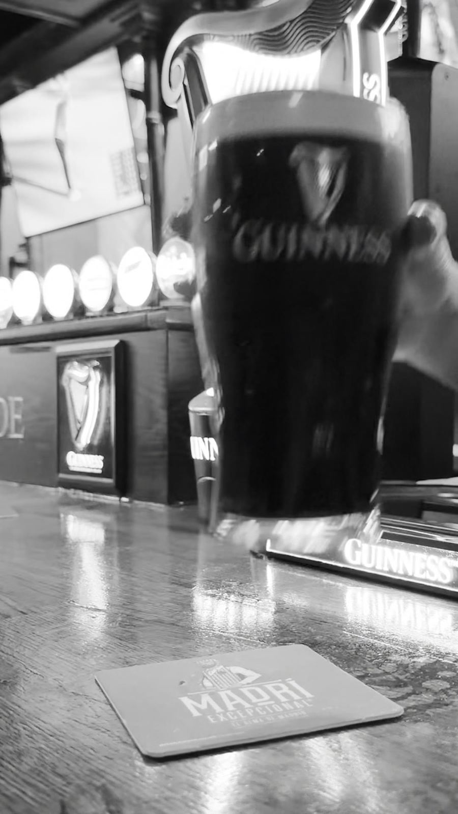 A pint of Guinness on the bar in black and white